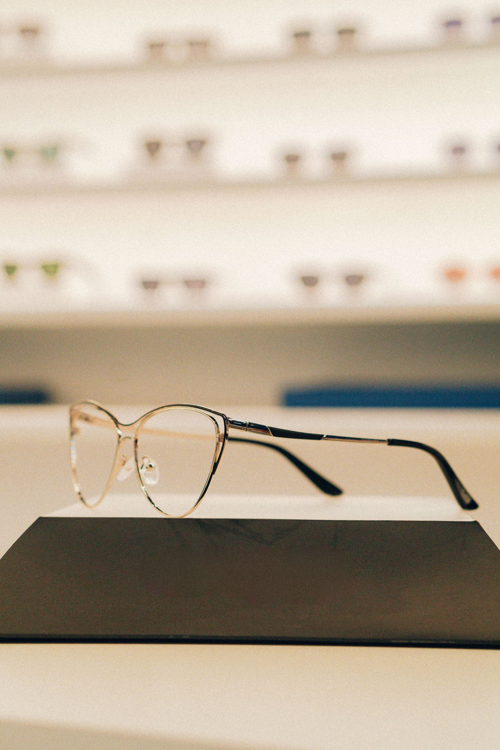 Detalhe de armação de óculos com frente transparente e haste colorida.